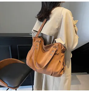 Vue détaillée du grand sac cabas caramel avec œillets métalliques et bandoulière réglable