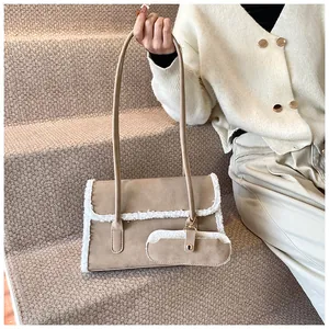 Détail du sac sous l'aisselle en daim avec bordure en laine et petite pochette amovible