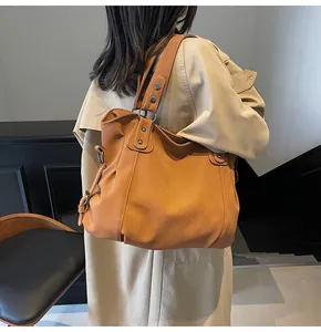 Vue détaillée du grand sac cabas marron avec rivets argentés et large bandoulière