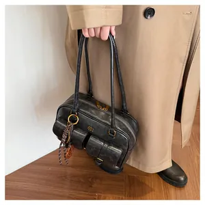 Detail of vintage black matte leather shoulder bag with buckle pockets and double handles