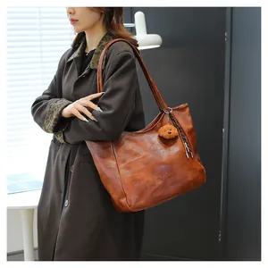 Dettaglio borsa tote in pelle testa di moro con logo impresso e ciondolo a orso