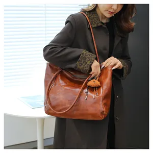 Scatto lifestyle di una grande borsa tote retrò marrone con ciondolo a forma di orso