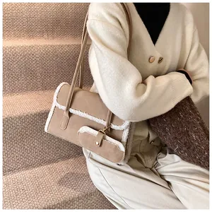 Gros plan sur le sac en daim kaki avec bordure en laine d'agneau et boucle dorée élégante
