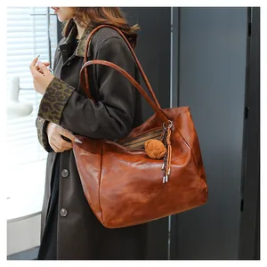 Dettaglio della borsa tote marrone con cerniera e incisione del logo del marchio TonTon