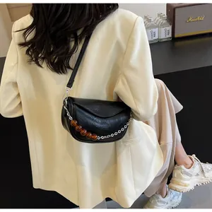 Detalle del bolso nube negro fruncido con cuentas de ámbar y cadena plateada