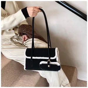 Détail du sac à bandoulière noir avec bordure en molleton blanc et mini pochette décorative