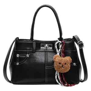 Sac à main Kelly chic en cuir PU noir avec coutures blanches et breloque ours en peluche