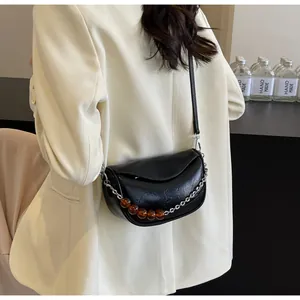 Detalle del bolso nube negro con textura plisada vintage y cadena de cuentas de ámbar