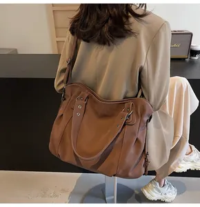 Détail du grand cabas en cuir PU marron foncé avec boucles argentées et bandoulière