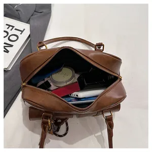 Macro view of a retro brown leather bowling bag showing large interior storage capacity