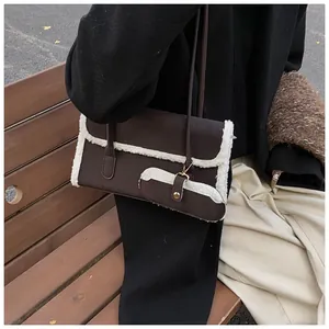 Détail du sac sous le bras en cuir marron foncé avec bordure en fausse fourrure blanche