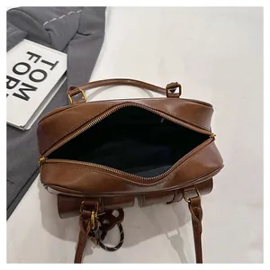 Top view of brown leather Boston bag showing spacious interior with black lining and gold zipper