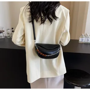 Detalle del bolso nube negro minimalista con cuero plisado y cadena de cuentas acrílicas