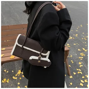 Détail du sac sous le bras en cuir marron avec bordure polaire et mini pochette suspendue