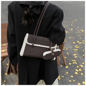 Détail du sac sous le bras en cuir marron foncé avec bordure en polaire blanche