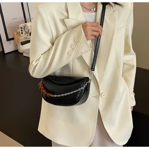 Detalle de bolso de silla negro con cadena plateada y cuentas de acrílico ámbar