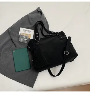 Détail du grand sac cabas noir avec ferrures argentées et bandoulière réglable pratique
