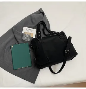 Détail du grand sac cabas noir avec poignées renforcées et bandoulière réglable