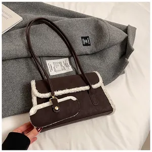 Détail du sac sous le bras en daim café avec bordure en fausse fourrure blanche sur laine