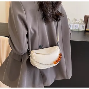 Detalle del bolso nube crema con cuero plisado y decoración de cadena de cuentas de ámbar