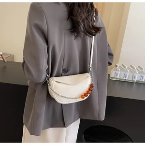 Detalle del bolso nube blanco roto con textura de cuero plisado y cadena de ámbar