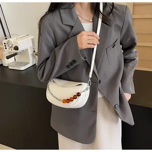 Detalle del bolso nube blanco crema con cadena de cuentas ámbar y cuero texturizado