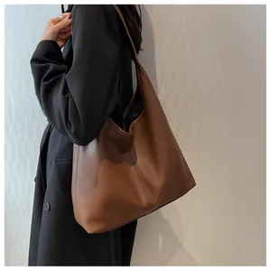 Macro shot of large brown pebbled leather tote bag showing texture and handle detail