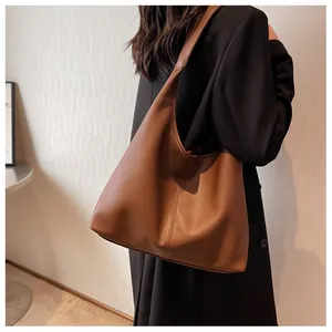 Close-up of a brown leather Hobo bag showing vertical stitching and grainy texture