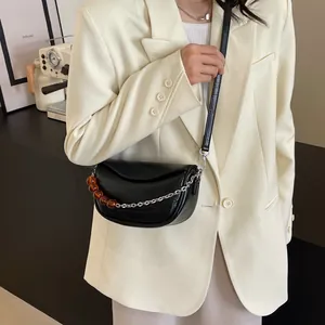 Elegante bolso nube negro con cuentas de ámbar y cadena metálica lucido por modelo