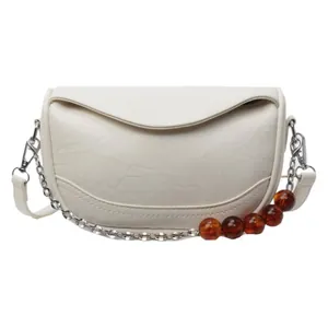 Bolso chic de media luna beige con correa de cadena plateada y cuentas ámbar