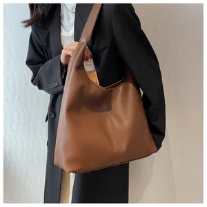 Detailed view of brown lychee-textured leather tote bag with structural stitching