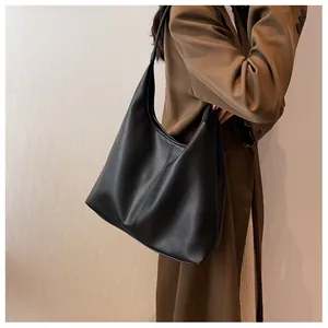 Detailed view of black lychee grain large capacity shoulder hobo bag on model