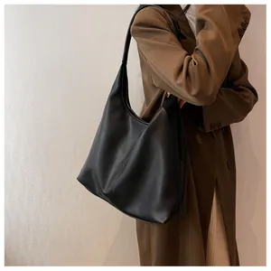 Detail shot of black pebbled leather large tote bag with minimalist hobo bucket design