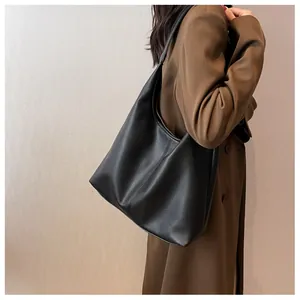 Detail of black lychee grain leather hobo bag showing texture and wide shoulder strap