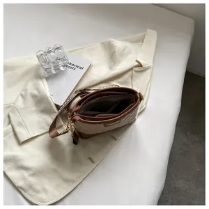 Gros plan du sac seau matelassé marron montrant les poches intérieures et dorures