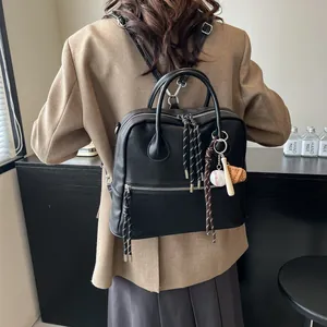 Zaino a cartella vintage in pelle nera da donna con ciondoli a tema baseball chic