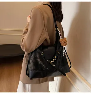 Detail of large matte tote bag with teddy bear charm and silk scarf on a model