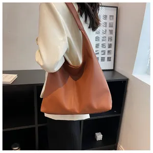 Macro detail of caramel brown lychee grain hobo bag showing texture and leather strap