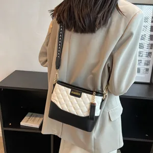 Sac seau matelassé noir et blanc chic avec large bandoulière à motifs sur un mannequin