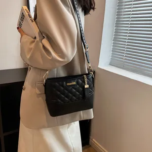 Sac seau matelassé noir chic avec logo doré et bandoulière tissée élégante pour femme