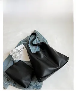 Detail view of large black PU leather tote bag set with matching zipper pouch and strap