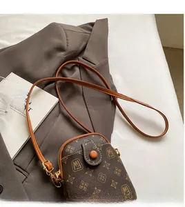 Detail of the vintage monogram mobile phone bag with adjustable strap and metal hardware