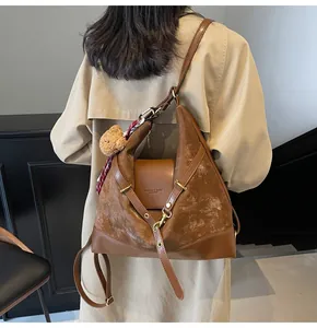 Detail of vintage brown suede patchwork tote bag with fashion embossing and scarf decor