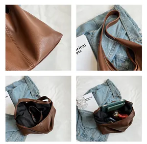 Detail showing brown pebble grain leather texture and spacious interior of the tote bag