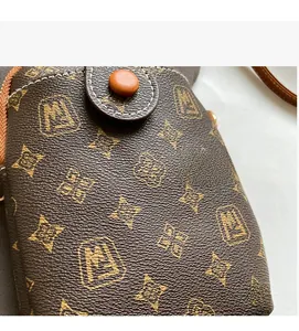 Close-up of vintage monogram mini bag showing leather texture and orange buckle detail