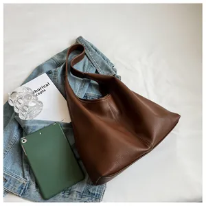 Detail view of large dark brown lychee texture leather tote bag in a lifestyle setting