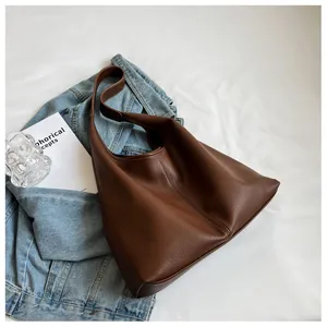 Detailed view of brown lychee grain leather tote bag with reinforced stitching and wide strap