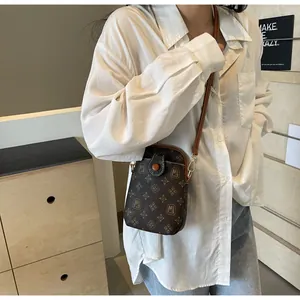 Detailed macro view of vintage MJ pattern on brown leather crossbody phone bag