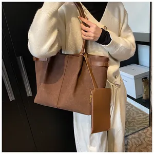 Detail van donkerbruine matte tote bag met bijpassend muntzakje en rond handvat
