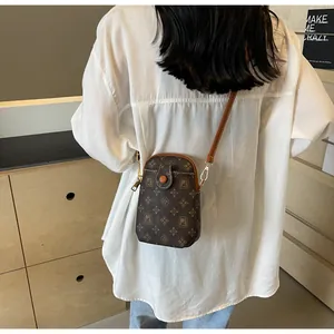 Close-up of vintage monogram brown mini crossbody phone bag with gold metal buckle